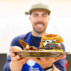 Chef Andy Hay holding up a plate of food