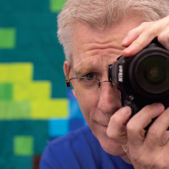 Photographer Andy Conrad posing with a camera in hand